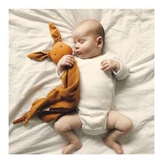 a baby is laying down with a stuffed animal