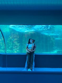 a man and woman standing in front of an aquarium