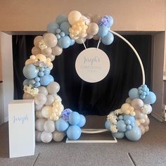 a balloon arch with blue, white and silver balloons in the shape of a circle