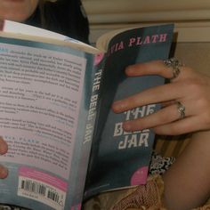 a woman is reading a book on the couch