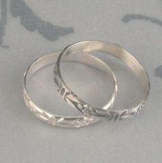 Antique Style Ring Romance in the Garden Sterling Silver Wedding Band Stacking Ring Patterned Silver Ring Flower Band Vintage Style Ring This lovely little ring is hand forged from solid sterling silver pattern wire. It features a deco flower pattern with lines and a daisy around the entire surface. It is 2.75mm wide and a slim .7mm thick. It can be made just for you in any size and can be either oxidized and brushed (top) or high polished (bottom). Looking for a set? https://www.etsy.com/listin Adjustable Etched Wedding Bands, Wedding Adjustable Etched Bands, Wedding Bands With Etched Detail And Adjustable Fit, Stackable Flower Ring For Wedding, Stackable Flower Ring With Round Band For Wedding, Nickel Free Silver Engraved Ring For Wedding, Nickel Free Adjustable Stackable Wedding Rings, Adjustable Nickel-free Stackable Rings For Wedding, Adjustable Stackable Toe Rings For Wedding