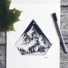 an ink drawing of mountains and trees with a leaf on the table next to it