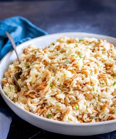 rice plas with orzo in a white bowl on a blue cloth and text overlay