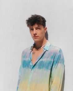 a young man wearing a tie dye shirt