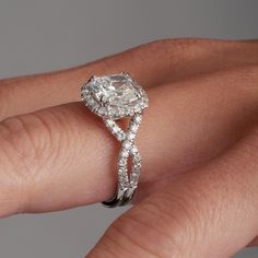 a woman's hand with a diamond ring on top of her finger and an engagement band