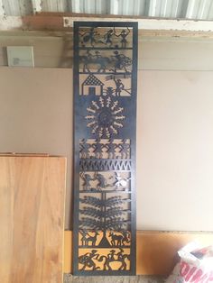 a tall metal wall hanging next to a wooden door