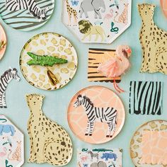 an assortment of animal themed plates on a blue background with zebras and giraffes