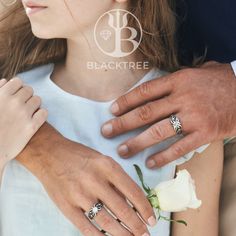 a man holding a woman's hand with two wedding rings on her finger and a rose in the other hand