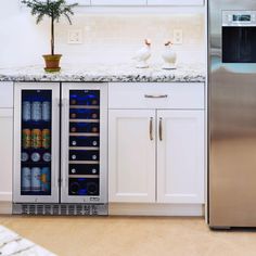 two white birds sitting on top of a kitchen counter next to a refrigerator freezer