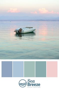 a boat floating on top of a large body of water next to the ocean with pink and blue hues