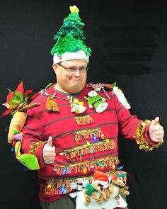 a man in a christmas sweater giving the thumbs up