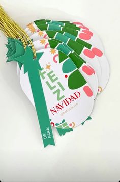 four tags with green ribbons on them sitting next to each other in front of a white background