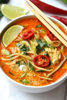 a white bowl filled with soup and chopsticks