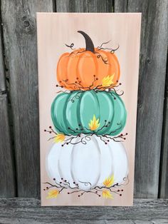 a painting of pumpkins stacked on top of each other in front of a wooden fence