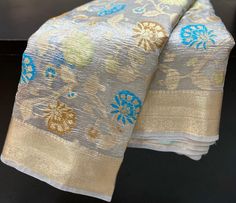 Beautiful floral semi tissue silk banarasi saree with crush tissue fabric available in elegant golden and silver colour. This saree has a 1 metre zari brocade blouse piece. Measurement: Saree-5.5 metres Blouse-1 metres Saree weight-550 grams (approx). Disclaimer- The colour of actual product may vary slightly due to photographic lighting conditions and difference in device screen resolution. Rest assure that you'll get the same product that you'll order from my shop within the time mention for delivery. Thanks for visiting our shop. Silver Tissue Silk Dupatta, Silver Art Silk Dupatta With Self Design, Traditional Silver Tissue Silk Dupatta, Silver Handloom Dupatta For Wedding, Silver Handloom Saree For Wedding, Silver Handloom Wedding Saree, Wedding Handloom Silver Dupatta, Wedding Silver Handloom Saree, Silver Tissue Silk Dupatta With Zari Work