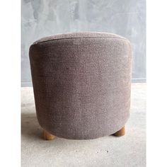 a round footstool with wooden legs in grey fabric