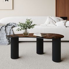 a living room with a white couch and black coffee table on carpeted flooring