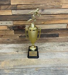 a gold trophy sitting on top of a wooden table