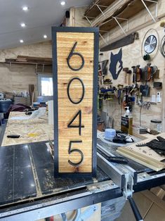 a wooden sign with the number sixty six on it in a shop area that is being worked on