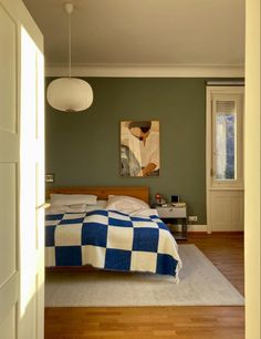 a bedroom with green walls and wooden floors