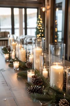 a long table with candles and pine cones on it