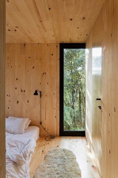 a bedroom with wooden walls and white bedding