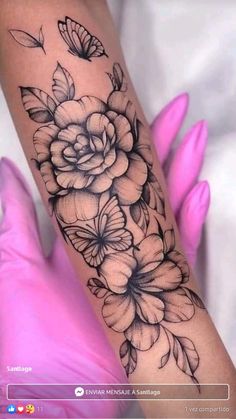 a woman's arm with flowers and butterflies on it