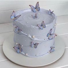 there is a white cake with blue butterflies on it