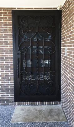 a black iron door in front of a brick wall