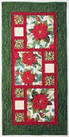 a quilted wall hanging with poinsettias and leaves on green fabric,