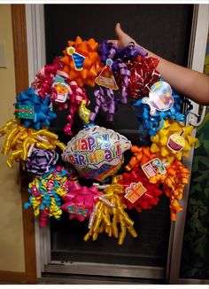 a birthday wreath with balloons and decorations on it