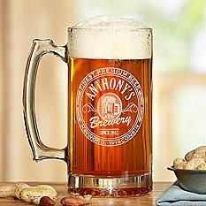 a beer mug sitting on top of a wooden table next to some cookies and crackers