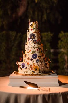 a three tiered cake sitting on top of a table next to a lit candle