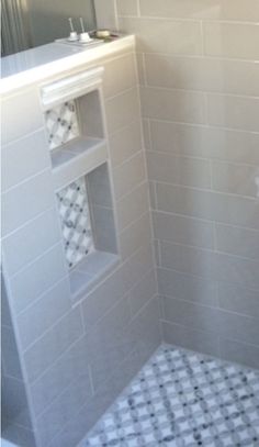 a white tiled bathroom with black and white tiles