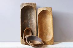 wooden spoons and bowls are lined up on a shelf