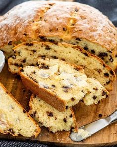 a loaf of bread with raisins and butter on a cutting board