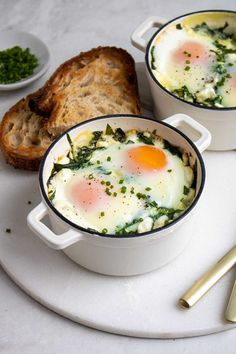 two white dishes filled with eggs and bread