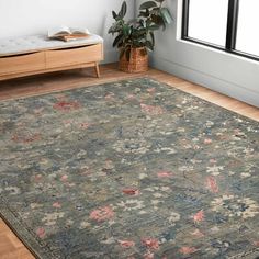 a large area rug in a living room with wooden floors and white walls, along with a window