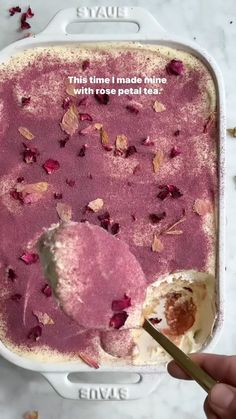 a person is holding a spoon over a bowl of ice cream with rose petals on it