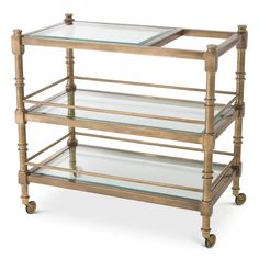 an antique brass serving cart with glass shelves