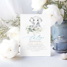 a card with an image of a dog on it next to white flowers and a blue vase