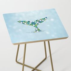 a small table with an artistic design on the top that is shaped like a bird