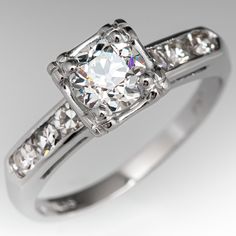 This 14k white gold vintage engagement ring is centered with an old European cut diamond weighing 0.62 carats and set into a four-prong head. The shoulders of the ring are each accented with three (3), channel set, round single cut diamonds. The ring measures 6.7mm at the top, rises 7.0mm above the finger, tapering to 1.8mm wide and 1.0mm thick at the base of the shank. The ring is currently a size 5.25 and we offer complimentary resizing to fit. Gia Certified Classic Cut Diamond Ring For Anniversary, Gia Certified Classic Cut Diamond Ring For Wedding, Gia Certified Classic Cut Diamond Anniversary Ring, Gia Certified Diamond Ring For Wedding, Vintage Cubic Zirconia Ring With Center Stone, Vintage White Gia Certified Rings, Antique Gia Certified Diamond Ring For Anniversary, Vintage Gia Certified White Diamond Ring, Vintage Silver Gia Certified Diamond Ring