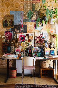 a desk with plants and pictures on the wall