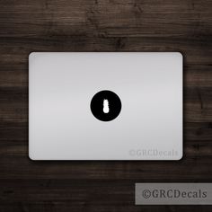 an apple macbook pro on a wooden surface with the logo for gfcdecals