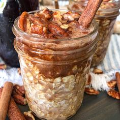 two jars filled with oatmeal sitting on top of a table next to cinnamon sticks