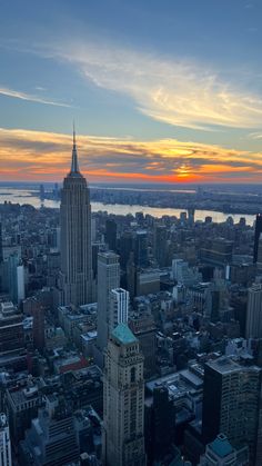 an aerial view of new york city with the empire building in the foreground at sunset