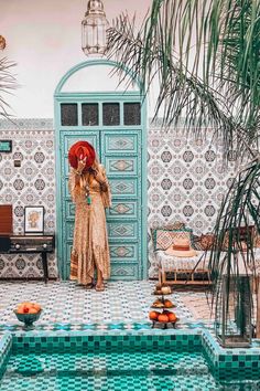 a woman with red hair is standing in front of a pool and looking into the mirror