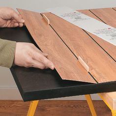 a person is cutting wood on top of a table