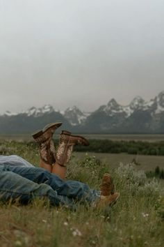 a person laying on the ground with their feet up in the air while wearing boots